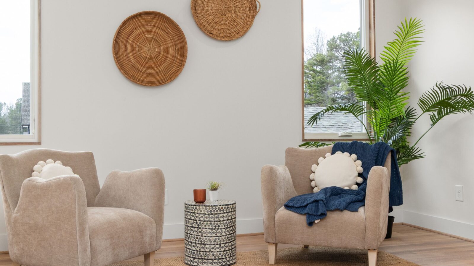 Two armchairs facing each other in a bright room with plants