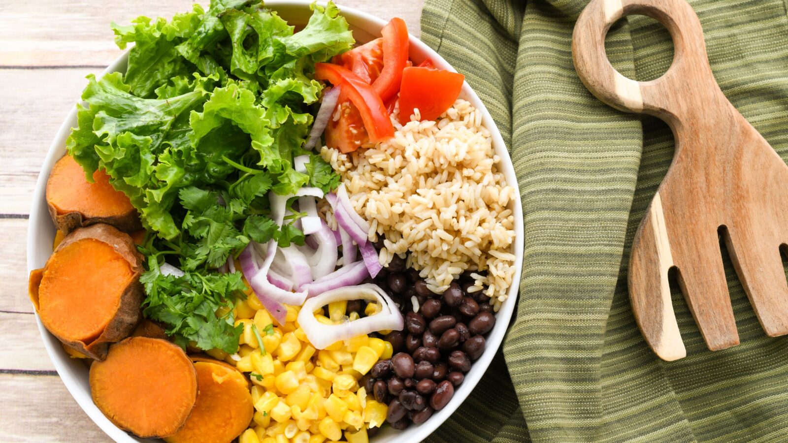 A bowl of beans, grains and colorful vegetables